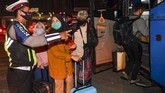 PEMUDIK TERJARING RAZIA PENYEKATAN DI TOL CIKARANG BARAT Petugas kepolisian mengarahkan calon pemudik yang terjaring razia penyekatan untuk menaiki bus yang akan membawa mereka ke Terminal Pulogebang, Jakarta, di Pintu Tol Cikarang Barat, Bekasi, Jawa Barat, Kamis (21/5/2020). Calon pemudik yang terjaring razia penyekatan oleh Polda Metro Jaya tersebut dibawa ke terminal Pulogebang untuk kemudian diarahkan kembali menuju Jakarta. ANTARA FOTO/Nova Wahyudi/aww.