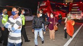 PEMUDIK TERJARING RAZIA PENYEKATAN DI TOL CIKARANG BARAT Petugas kepolisian mengarahkan calon pemudik yang terjaring razia penyekatan untuk menaiki bus yang akan membawa mereka ke Terminal Pulogebang, Jakarta, di Pintu Tol Cikarang Barat, Bekasi, Jawa Barat, Kamis (21/5/2020). Calon pemudik yang terjaring razia penyekatan oleh Polda Metro Jaya tersebut dibawa ke terminal Pulogebang untuk kemudian diarahkan kembali menuju Jakarta. ANTARA FOTO/Nova Wahyudi/aww.