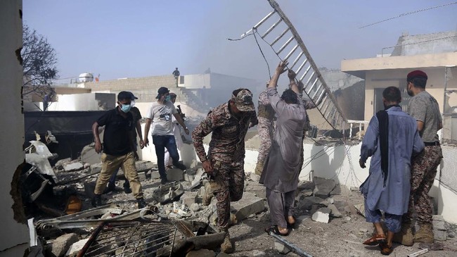 Rescue work is in progress at the site of a plane crash in Karachi, Pakistan, Friday, May 22, 2020. An aviation official says a passenger plane belonging to state-run Pakistan International Airlines carrying more than 100 passengers and crew has crashed near the southern port city of Karachi. There were no immediate reports on the number of casualties. (AP Photo/Fareed Khan)