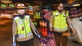 PEMUDIK TERJARING RAZIA PENYEKATAN DI TOL CIKARANG BARAT Petugas kepolisian membantu membawakan barang-barang milik calon pemudik yang terjaring razia penyekatan di Pintu Tol Cikarang Barat, Bekasi, Jawa Barat, Kamis (21/5/2020). Calon pemudik yang terjaring razia penyekatan oleh Polda Metro Jaya tersebut dibawa ke terminal Pulogebang untuk kemudian diarahkan kembali menuju Jakarta. ANTARA FOTO/Nova Wahyudi/aww.