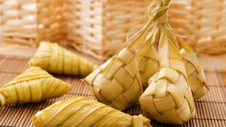 Ketupat or packed rice dumpling. Delicious traditional Malay ramadan food. Popular Malaysian food on bamboo mat.