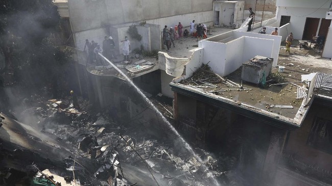 Fire brigade staff try to put out fire caused by plane crash in Karachi, Pakistan, Friday, May 22, 2020. An aviation official says a passenger plane belonging to state-run Pakistan International Airlines carrying more than 100 passengers and crew has crashed near the southern port city of Karachi. There were no immediate reports on the number of casualties. (AP Photo/Fareed Khan)