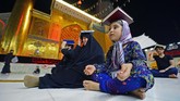 Nyalang Edisi 23 Mei 2020 Shiite Muslims gather, albeit in fewer numbers due to the COVID-19 pandemic, at the Imam Ali shrine in the central Iraqi holy city of Najaf late on May 16, 2020, to mark Lailat al-Qadr, a night in the holy month of Ramadan during which the Koran was first revealed to the Prophet Mohammed in the seventh century. - Worshippers placed copies of the Koran on their heads to convey veneration during the overnight prayers in a centuries-old ritual, as they pleaded to God to rid them of the ongoing novel coronavirus pandemic. (Photo by Haidar HAMDANI / AFP)