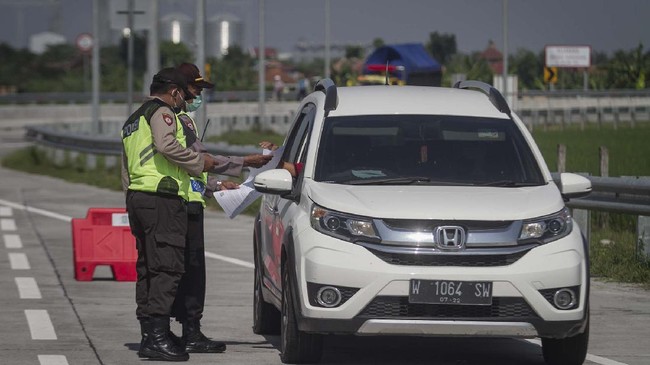 Petugas Kepolisian Polresta Sragen memeriksa kendaraan yang keluar tol melalui Gerbang Tol Sragen, Jawa Tengah, Jumat (22/5/2020). Pemeriksaan tersebut sebagai upaya penyekatan pemudik yang hendak masuk Sragen untuk memutus rantai penyebaran COVID-19. ANTARA FOTO/Mohammad Ayudha/prs.