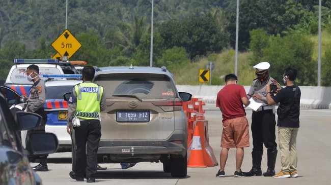 Petugas Kepolisian Polda Lampung memeriksa kendaraan yang keluar jalan tol melalui gerbang tol Bakauheni Selatan di Lampung Selatan, Lampung, Sabtu (23/5/2020). Pemeriksaan tersebut sebagai upaya penyekatan pemudik yang hendak keluar atau masuk Provinsi Lampung untuk memutus rantai penyebaran COVID-19. ANTARA FOTO/Ardiansyah/wsj.