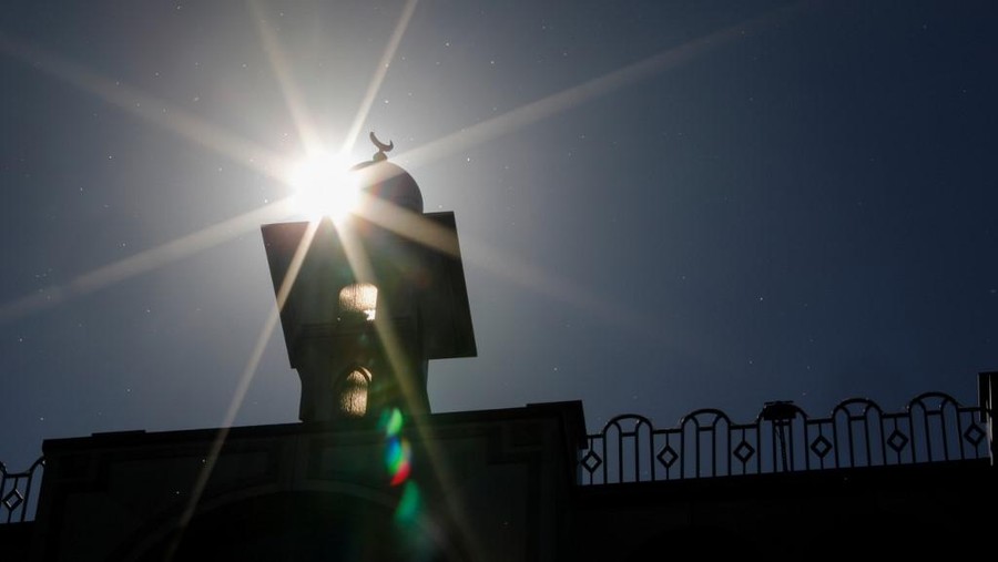 The sun shines behind the Omar Mosque in Berlin's Kreuzberg district just hours before the start of the Muslim holy fasting month of Ramadan on April 23, 2020. (Photo by David GANNON / AFP)