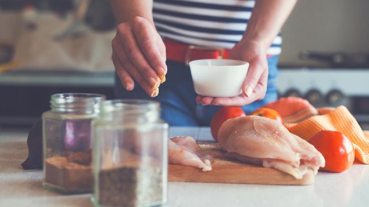 483160642 young woman preparing chicken meat