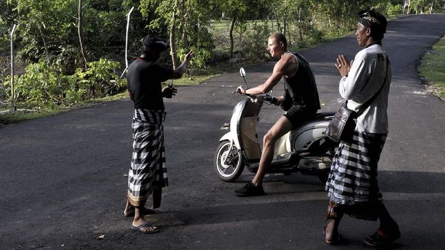 Pecalang meminta wisatawan mancanegara balik arah terkait penutupan sementara kawasan wisata Pantai Balangan, Badung.