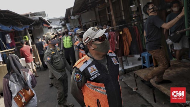 Petugas gabungan dari Satpol PP dan Polsek Tanah Abang melakukan penertiban dengan menghimbau terhadap pedagang Pasar Tanah Abang agar segera menutup kiosnya, Jakarta, Sabtu, 23 Mei 2020. Penertiban tersebut dilakukan guna memutus rantai penyebaran virus Covid-19. CNN Indonesia/Bisma Septalisma