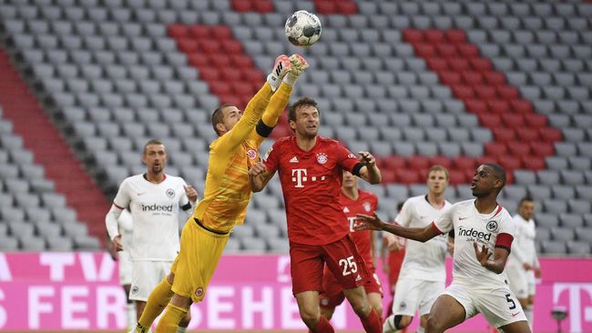 Bayern Munchen vs Eintracht Frankfurt Bayern Munich's Thomas Muller in action with Eintracht Frankfurt's Kevin Trapp during the German Bundesliga soccer match between Bayern Munich and Eintracht Frankfurt in Munich, Germany, Saturday, May 23, 2020. (Andreas Gebert/pool via AP)