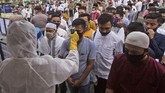 Nusantara Sambut Idul Fitri Dibawah Bayang-Bayang Corona A health worker in a protective suit checks the temperature of worshippers prior to entering Al Mashun Grand Mosque's compound to attend an Eid al Fitr prayer amid concerns of coronavirus outbreak in Medan, North Sumatra, Indonesia, Sunday, May 24, 2020. Millions of people in the world's largest Muslim nation are marking a muted and gloomy religious festival of Eid al-Fitr, the end of the fasting month of Ramadan - a usually joyous three-day celebration that has been significantly toned down as coronavirus cases soar. (AP Photo/Binsar Bakkara)