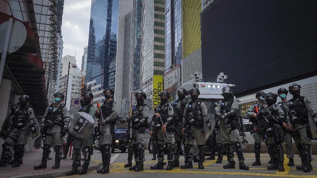 Riot police stand in formation in front of a water cannon tuck during a protest against Beijing's national security legislation in Causeway Bay in Hong Kong, Sunday, May 24, 2020. Hong Kong police fired volleys of tear gas in a popular shopping district as hundreds took to the streets Sunday to march against China's proposed tough national security legislation for the city. (AP Photo/Vincent Yu)