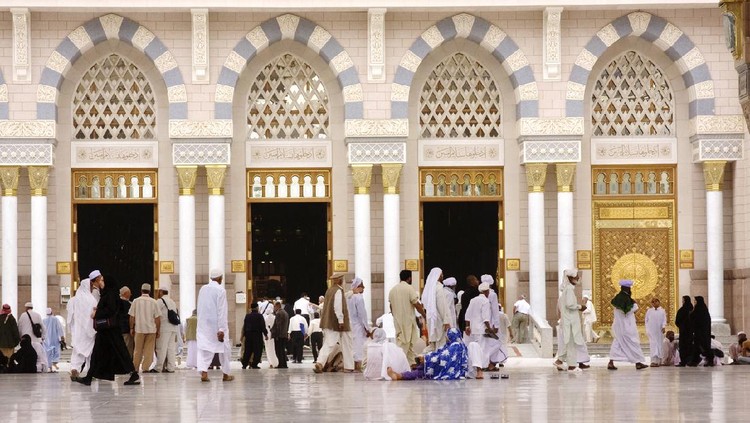 Medina, Saudi Arabia - April 16, 2011: Muslim pilgrims entering to Masjid al-Nabawi ( Prophet's Mosque ) for the noon prayer. As the final resting place of the Prophet Muhammad, it is considered the second holiest site in Islam by Muslims (the first being the Masjid al-Haram in Mecca).