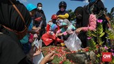 ANTARA TRADISI DAN ANCAMAN CORONA Warga melakukan ziarah kubur hari kedua Idul Fitri di TPU Semper, Jakarta Utara, Senin, 25 Mei 2020. Meskipun PSBB masih berlangsung di DKI Jakarta, warga tak surut mendatangi TPU melakukan tradisi ziarah. CNNIndonesia/Safir Makki