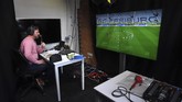 Sisi Lain Bundesliga Soccer commentator Dan O'Hagan commentates on the German Bundesliga soccer match between Freiburg and Werder Bremen remotely from a studio in Camden Town, London, Saturday May 23, 2020. The Bundesliga is the only soccer major league to have resumed since the start of the coronavirus lockdown and with increased global demand matches are also being provided to customers with a commentary in English. (AP Photo/Alberto Pezzali)