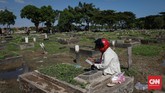 ANTARA TRADISI DAN ANCAMAN CORONA Warga melakukan ziarah kubur hari kedua Idul Fitri di TPU Semper, Jakarta Utara, Senin, 25 Mei 2020. Meskipun PSBB masih berlangsung di DKI Jakarta, warga tak surut mendatangi TPU melakukan tradisi ziarah. CNNIndonesia/Safir Makki