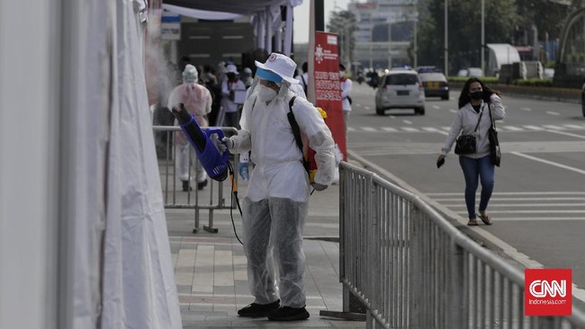 Sejumlah pekerja berjalan dengan latar belakang gedung perkantoran, Jakarta, Kamis (16/4/2020). H+2 lebaran jalan Jakarta terpantau ramai selama masa Pembatasan Sosial Berskala Besar (PSBB) tahap tiga di Jakarta. (CNN Indonesia/ Adhi Wicaksono)