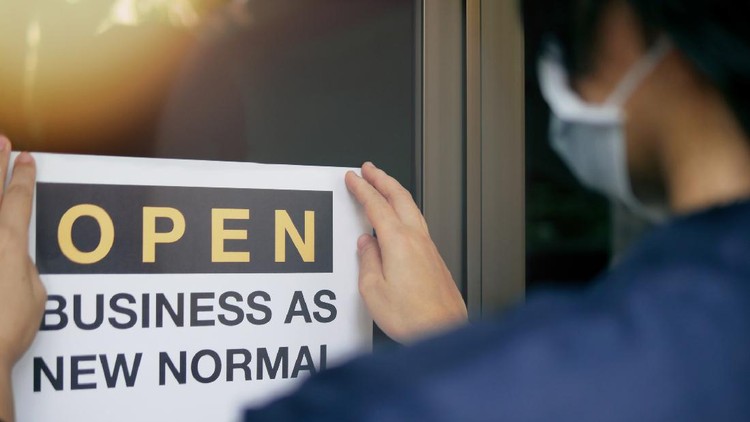 Reopening for business adapt to new normal in the novel Coronavirus COVID-19 pandemic. Rear view of business owner wearing medical mask placing open sign 