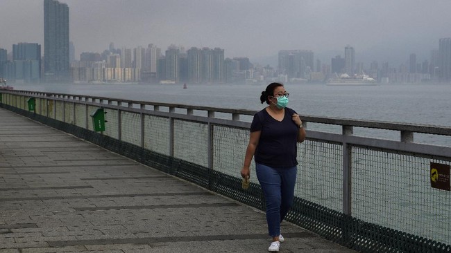 Associated Press reporter Zen Soo walks along the Quarry Bay Promenade in Hong Kong on the first day of freedom after 14 days of home quarantine in Hong Kong, April 19, 2020. (AP Photo/Vincent Yu)