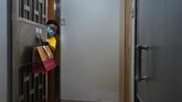 Karantina dan Gelang Untuk Warga yang Kembali ke Hong Kong Associated Press reporter Zen Soo collects her food delivery order while serving a two-week home quarantine, hung on her gate handle as part of