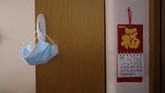 Karantina dan Gelang Untuk Warga yang Kembali ke Hong Kong A mask hangs on a hook at the home of Associated Press reporter Zen Soo, who was serving a 14-day home quarantine in Hong Kong, April 17, 2020. (AP Photo/Vincent Yu)