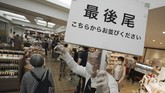 Denyut Bisnis Jepang Ketika Darurat Corona Dicabut An employee holds a sign to show the last in the queue as shoppers maintain a safe social distance between each other as they wait in line for casher at a food section of the Matsuya Ginza department store which partially reopens Monday, May 25, 2020, in Tokyo. Japan's Prime Minister Shinzo Abe is expected to remove a coronavirus state of emergency from Tokyo and four other remaining prefectures later in the day. Japanese words read as