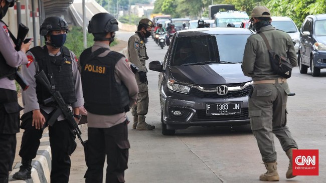 Petugas gabungan (TNI, Polisi, Satpol PP) melakukan pengecekan surat izin keluar masuk (SIKM)  Jakarta bagi pengendara motor dan mobil di check point Lampiri, Jakarta Timur, Rabu, 27 Mei 2020. Bagi pengendara mobil maupun motor yang ber-plat diluar Jabodetabek dan tak dapat menunjukkan SIKM diwajibkan memutar balik kendaraan. CNNIndonesia/Safir Makki