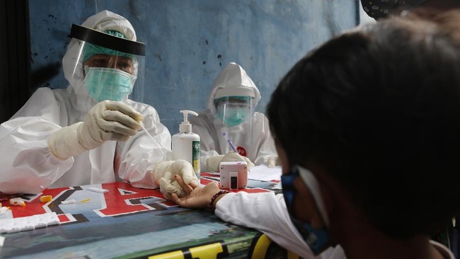 A coronavirus antibody test from health workers at a village in Bali, Indonesia, Wednesday, May 27, 2020. (AP Photo/Firdia Lisnawati)