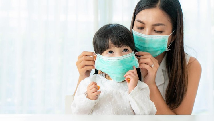 Stay at home quarantine coronavirus pandemic prevention.Mother and daughter in protective medical masks standing near on window and looks out window.