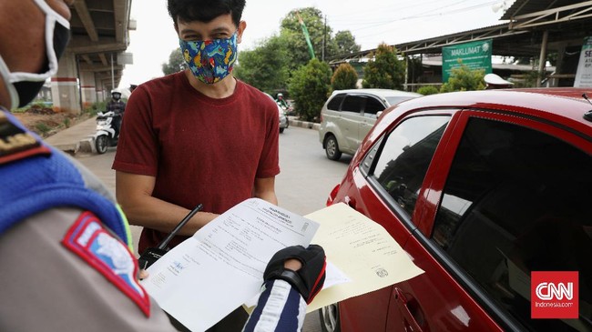 Petugas gabungan (TNI, Polisi, Satpol PP) melakukan pengecekan surat izin keluar masuk (SIKM)  Jakarta bagi pengendara motor dan mobil di check point Lampiri, Jakarta Timur, Rabu, 27 Mei 2020. Bagi pengendara mobil maupun motor yang ber-plat diluar Jabodetabek dan tak dapat menunjukkan SIKM diwajibkan memutar balik kendaraan. CNNIndonesia/Safir Makki