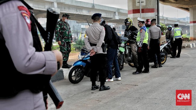 Petugas gabungan (TNI, Polisi, Satpol PP) melakukan pengecekan surat izin keluar masuk (SIKM)  Jakarta bagi pengendara motor dan mobil di check point Lampiri, Jakarta Timur, Rabu, 27 Mei 2020. Bagi pengendara mobil maupun motor yang ber-plat diluar Jabodetabek dan tak dapat menunjukkan SIKM diwajibkan memutar balik kendaraan. CNNIndonesia/Safir Makki