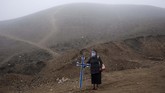 Peru Jadi Hotspot Penyebaran COVID-19 Noly Suarez, 53, holds a cross during the burial of her brother Flavio Juarez, 50, who died from COVID-19, at the Nueva Esperanza cemetery on the outskirts of Lima, Peru, Tuesday, May 26, 2020. (AP Photo/Rodrigo Abd)