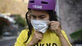 Impian Berlaga di Olimpiade Bagi Atlet BMX Venezuela yang Terkurung Venezuelan Olympic medalist Stefany Hernandez, a BMX racing cyclist, puts on a face mask amid the COVID-19 pandemic before training in Caracas, Venezuela, Saturday, April 25, 2020. Despite a quarantine to curb the spread of the new coronavirus, Hernandez trains three times a week in hopes of qualifying for the 2021 Tokyo Summer Olympics. (AP Photo/Matias Delacroix)