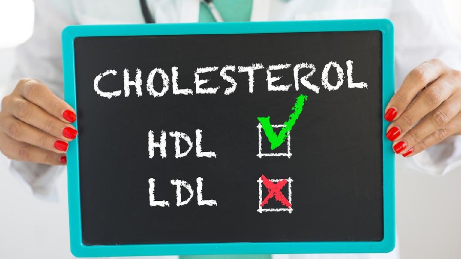 Kolesterol Good HDL and bad LDL cholesterol written on blackboard by unrecognizable doctor with stethoscope