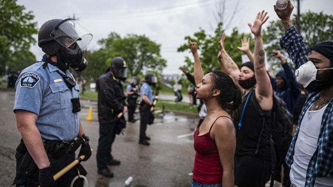 Protesters and police face each other during a rally for George Floyd in Minneapolis on Tuesday, May 26, 2020. Four Minneapolis officers involved in the arrest of the black man who died in police custody were fired Tuesday, hours after a bystander’s video showed an officer kneeling on the handcuffed man’s neck, even after he pleaded that he could not breathe and stopped moving. (Richard Tsong-Taatarii/Star Tribune via AP)