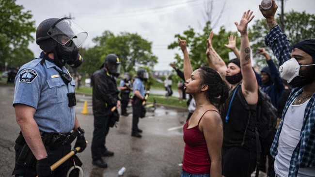 Protesters and police face each other during a rally for George Floyd in Minneapolis on Tuesday, May 26, 2020. Four Minneapolis officers involved in the arrest of the black man who died in police custody were fired Tuesday, hours after a bystander’s video showed an officer kneeling on the handcuffed man’s neck, even after he pleaded that he could not breathe and stopped moving. (Richard Tsong-Taatarii/Star Tribune via AP)