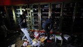 Kerusuhan di Minneapolis Berlanjut People take items from a liquor store Thursday, May 28, 2020, in Minneapolis. Protests over the death of George Floyd, a black man who died in police custody Monday, broke out in Minneapolis for a third straight night. (AP Photo/John Minchillo)