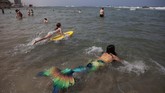Komunitas Putri Duyung Israel A member of the Israeli Mermaids Community swim with a mermaid tail at the beachfront in Bat Yam, near Tel Aviv, Israel, Saturday, May 23, 2020. Members of the Israeli mermaid community gathered at the beachfront to mark the beginning of the bathing season. (AP Photo/Oded Balilty)