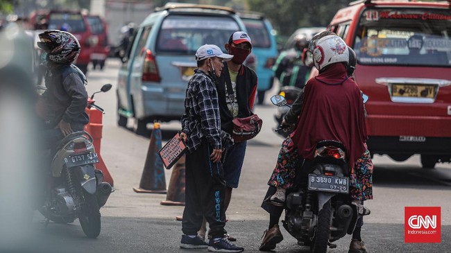 Sejumlah penjual jasa servis handphone Pusat Grosir Cililitan mempromosikan jasa servis handphone di pinggir jalan raya Cililitan, Jakarta, Jumat, 29 Mei 2020. Selama PSBB berlangsung, para para penjual jasa servis tersebut menawarkan jasanya hingga ke tepi jalan karena larangan membuka gerai  di pusat perbelanjaan tersebut. CNN Indonesia/Bisma Septalisma