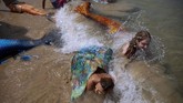 Komunitas Putri Duyung Israel Members of the Israeli Mermaids Community bathe in the sea with a mermaid tails at the beachfront in Bat Yam, near Tel Aviv, Israel, Saturday, May 23, 2020. Members of the Israeli mermaid community gathered at the beachfront to mark the beginning of the bathing season. (AP Photo/Oded Balilty)