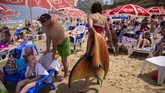 Komunitas Putri Duyung Israel A member of the Israeli Mermaids Community carries her mermaid tail after a swim at the beachfront in Bat Yam, near Tel Aviv, Israel, Saturday, May 23, 2020. Members of the Israeli mermaid community gathered at the beachfront to mark the beginning of the bathing season. (AP Photo/Oded Balilty)