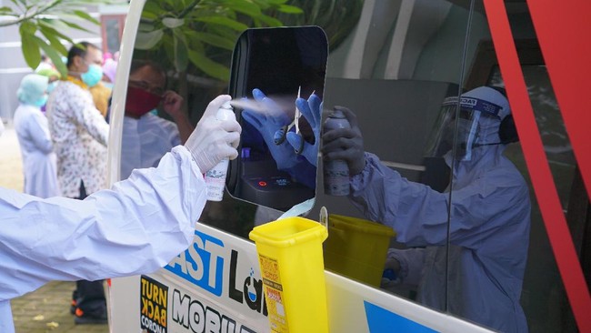 Petugas medis menyemprotkan cairan disinfektan pada peralatan dan jendela bilik pengambilan sampel lendir hidung dan tenggorokan mobil tes PCR keliling di Tulungagung, Jawa Timur, Jumat (29/5/2020). Lebih dari 200 orang yang terdiri dari tenaga medis di RSUD dr Iskak Tulungagung dan tiga puskesmas penyangga COVID-19, serta pasien berstatus PDP yang dkarantina di Rusunawa IAIN Tulungagung, diperiksa sampel lendir tenggorokannya untuk mendeteksi infeksi virus Corona atau SARS-Cov-2. ANTARA FOTO/Destyan Sujarwoko/wsj.