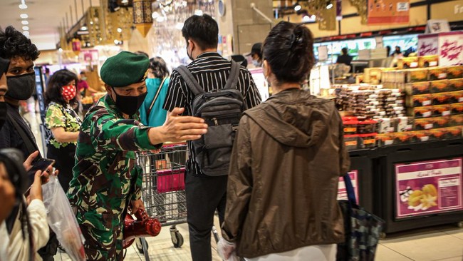 Personel TNI memberikan imbauan kepada pengunjung untuk tetap menjaga jarak di AEON Mall, Tangerang, Banten, Jumat (29/5/2020). Sejumlah aturan protokol kesehatan penyebaran COVID-19 diterapkan di pusat perbelanjaan tersebut seiring memasuki era normal baru di tengah pandemi COVID-19. ANTARA FOTO/Fauzan/wsj.