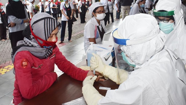 Petugas kesehatan mengambil sampel darah pekerja saat tes diagnostik cepat (rapid test) COVID-19 di sebuah pabrik rokok di Kabupaten Madiun, Jawa Timur, Rabu (27/5/2020). Rapid test yang dilakukan terhadap 890 pekerja di pabrik rokok tersebut dimaksudkan untuk mencegah penyebaran COVID-19 menyusul ditemukannya seorang pekerja terkonfirmasi positif COVID-19 di pabrik rokok tersebut. ANTARA FOTO/Siswowidodo/foc.