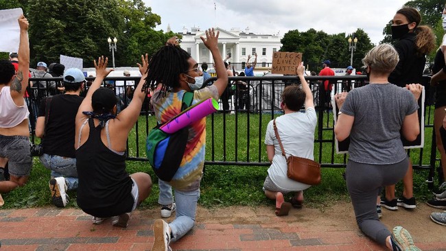 Protesters kneel as they gather outside the White House in Washington, DC, on May 29, 2020 in a demonstration over the death of George Floyd, a black man who died after a white policeman kneeled on his neck for several minutes. - Demonstrations are being held across the US after George Floyd died in police custody on May 25. (Photo by Nicholas Kamm / AFP)