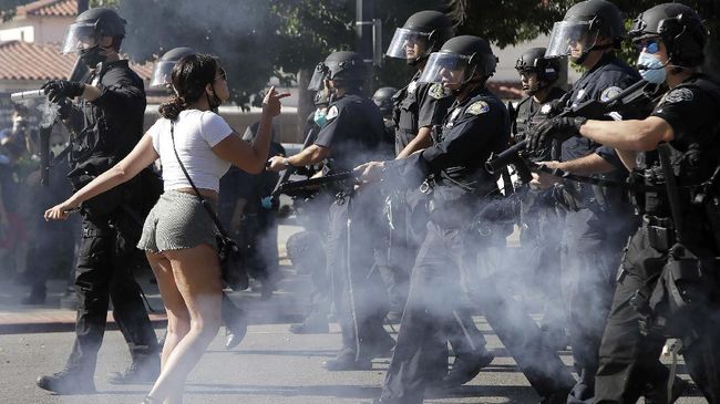 A protester confronts San Jose police as they advance on Friday, May 29, 2020, in San Jose, Calif., as people demonstrate nationwide in response to George Floyd dying while in police custody on Memorial Day, in Minneapolis. (AP Photo/Ben Margot)