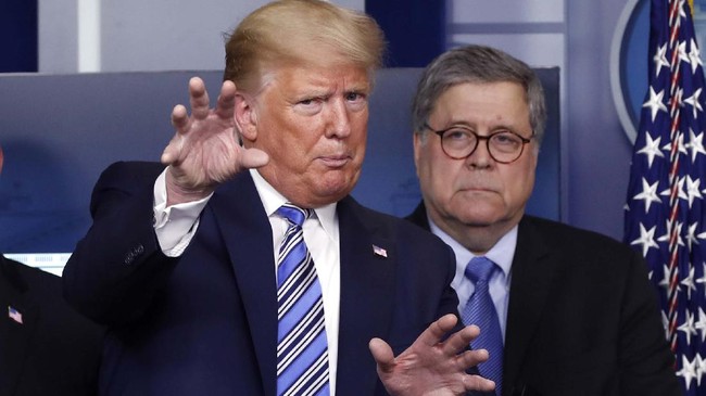 FILE- In this March 23, 2020 file photo, President Donald Trump talks during a briefing about the coronavirus in the James Brady Briefing Room, Monday, March 23, 2020, in Washington, as Attorney General William Barr looks on. Legislation to extend surveillance authorities that the FBI sees as vital in fighting terrorism was thrown in doubt Wednesday as President Donald Trump, the Justice Department and congressional Republicans all came out in opposition. (AP Photo/Alex Brandon)