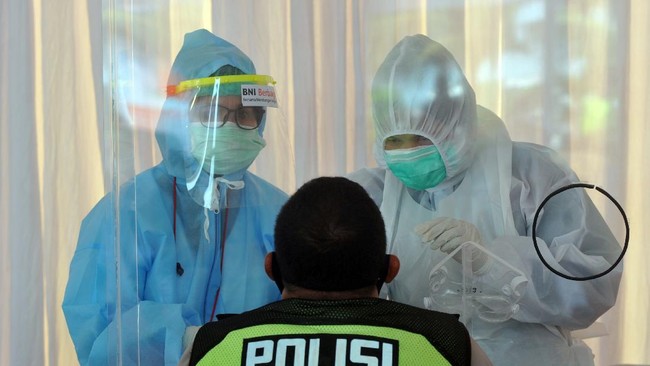 Petugas medis mengambil sampel lendir seorang petugas kepolisian, saat swab test di Padang, Sumatera Barat, Minggu (31/5/2020). PT BNI (Persero) Tbk bekerja sama dengan jaringan Rumah Sakit Bunda menggelar 2.000 swab test COVID-19 secara gratis bagi masyarakat di provinsi itu sebagai upaya membantu percepatan deteksi pasien. ANTARA FOTO/Iggoy el Fitra/foc.