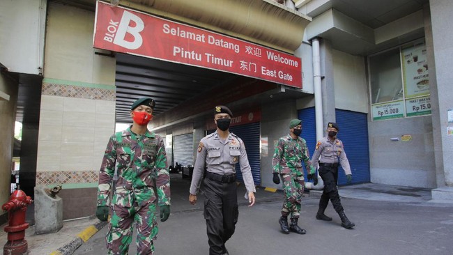 Anggota TNI dan Polri berjaga di kawasan Pasar Tanah Abang, Jakarta, Sabtu (30/5/2020). Personel TNI dan Polri disiagakan di sejumlah pusat kegiatan masyarakat untuk mengawal kedisiplinan warga dalam menjalankan protokol kesehatan, menyusul rencana penerapan tata kehidupan baru atau normal baru di ibu kota Jakarta. ANTARA FOTO/Reno Esnir/wsj. *** Local Caption ***