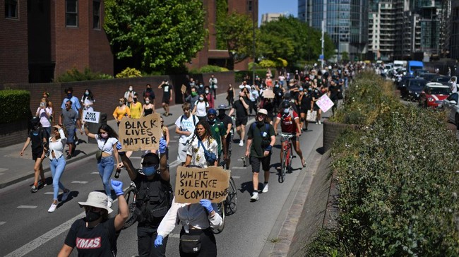 Demonstrators hold up placards as they march towards the US Embassy in central London on May 31, 2020 to protest the death of George Floyd, an unarmed black man who died after a police officer knelt on his neck for nearly nine minutes during an arrest in Minneapolis, USA. - Hundreds of people gathered in central London to protest the death of George Floyd, an unarmed black man who died while being arrested in Minneapolis, USA. (Photo by DANIEL LEAL-OLIVAS / AFP)